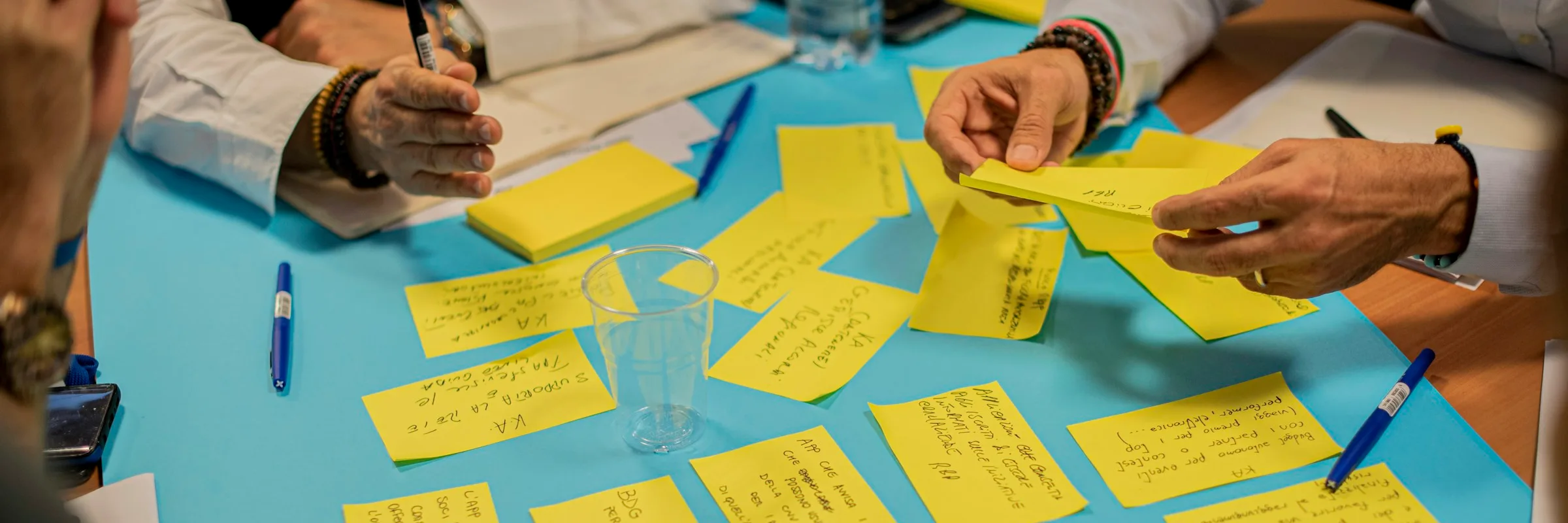 Mains disposant des post-its lors d'une session de brainstorming