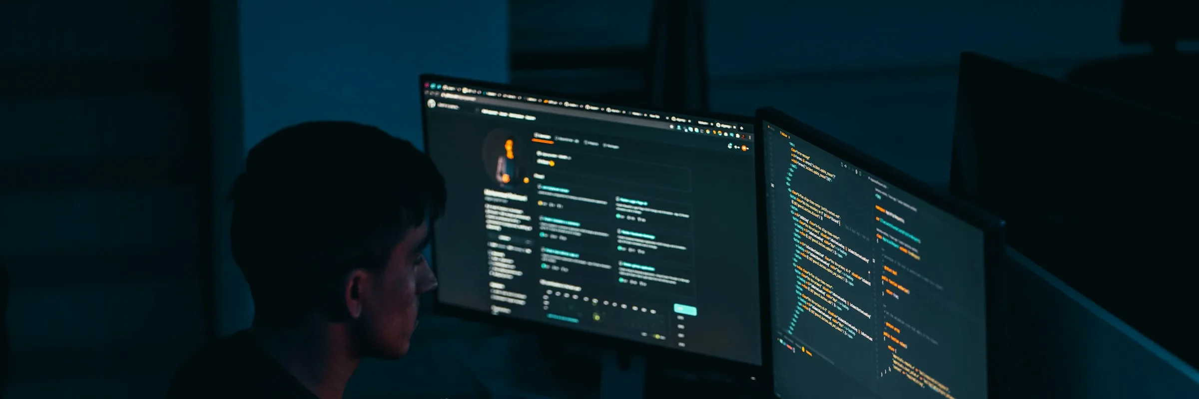 Développeur travaillant sur du code face à deux écrans, de nuit